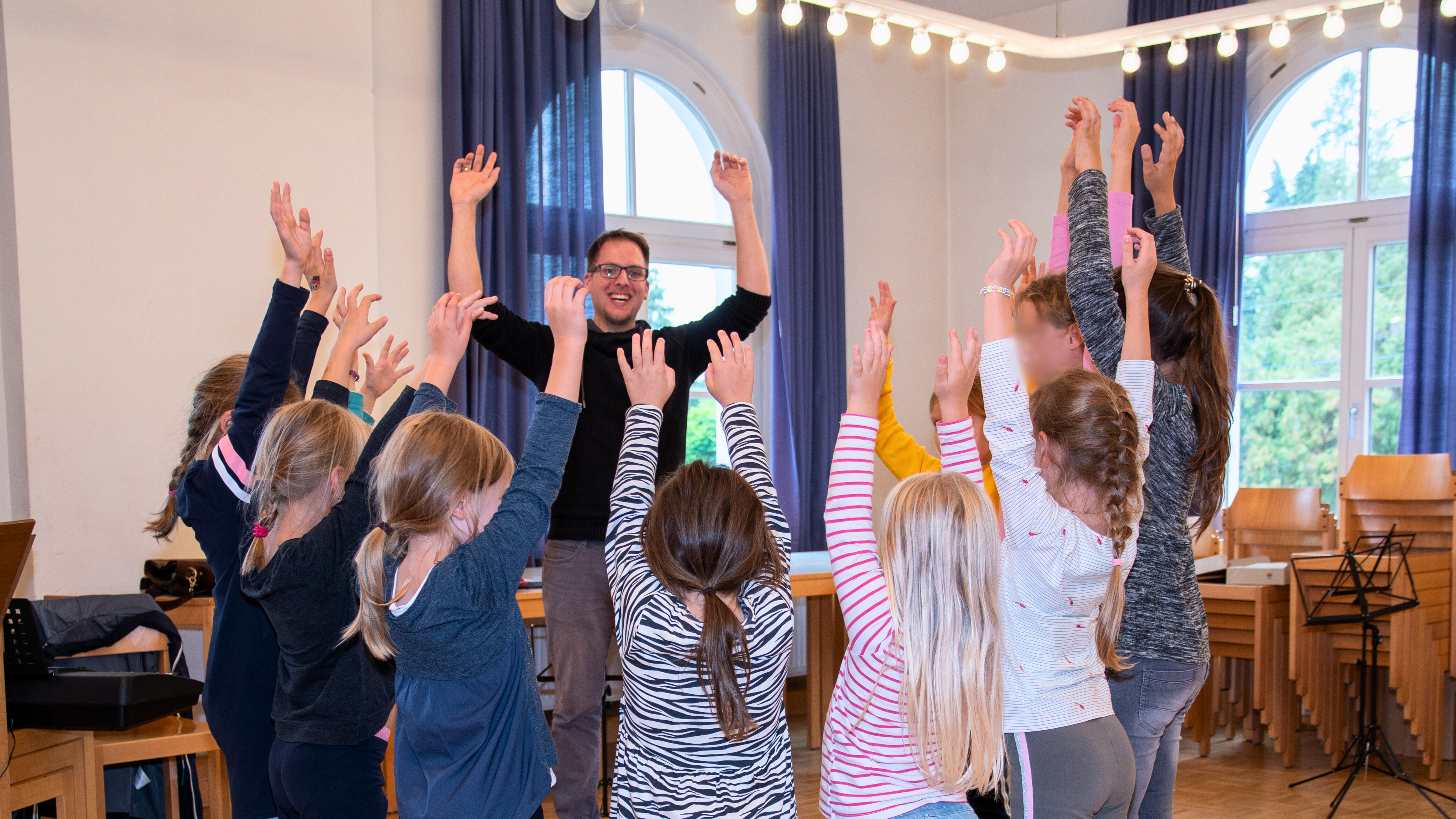 Das Bild zeigt Martin Honsberg mit dem Kinderchor
