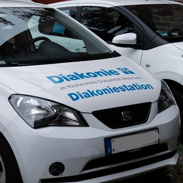 Weißer SEAT Mii PKW mit Aufschrift "Diakonie Diakoniestation im Kirchenkreis Düsseldorf-Mettmann."